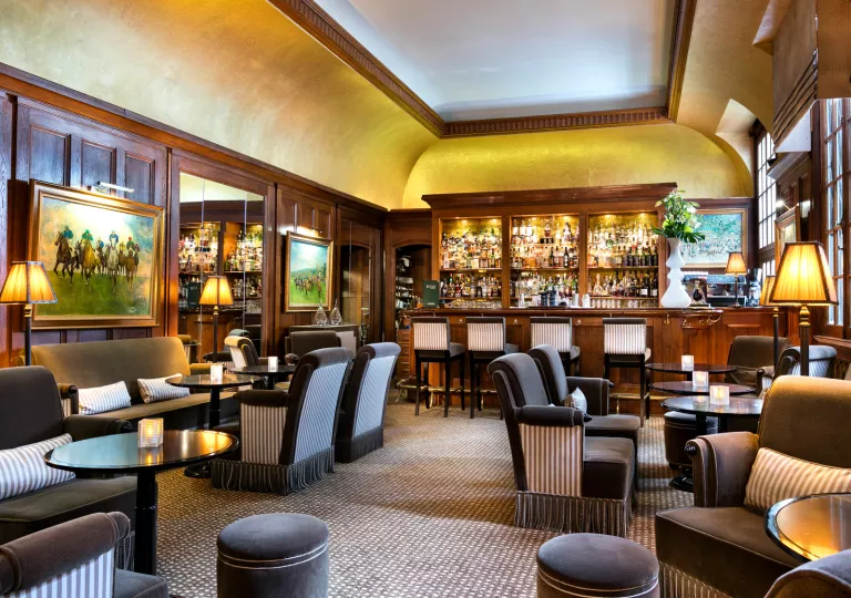 Indoor bar and lounge with black and white cushioned chairs and wooden walls