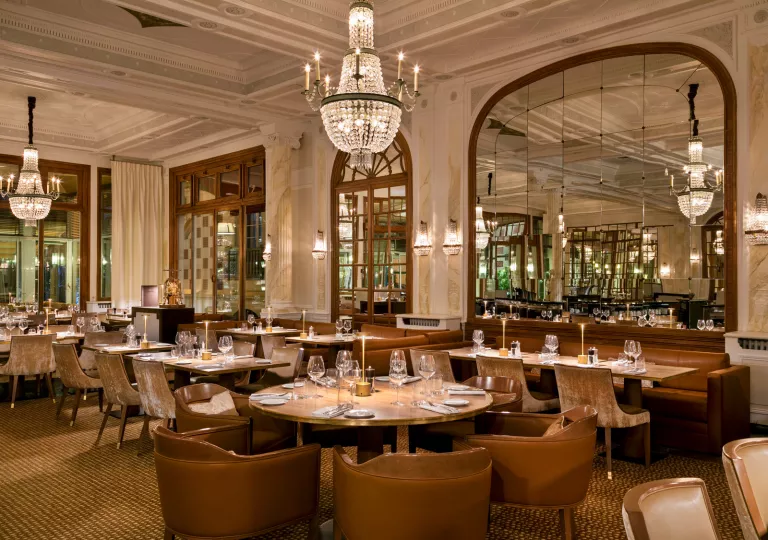 Indoor dining area with cushioned, leather seats and chandeliers dangling
