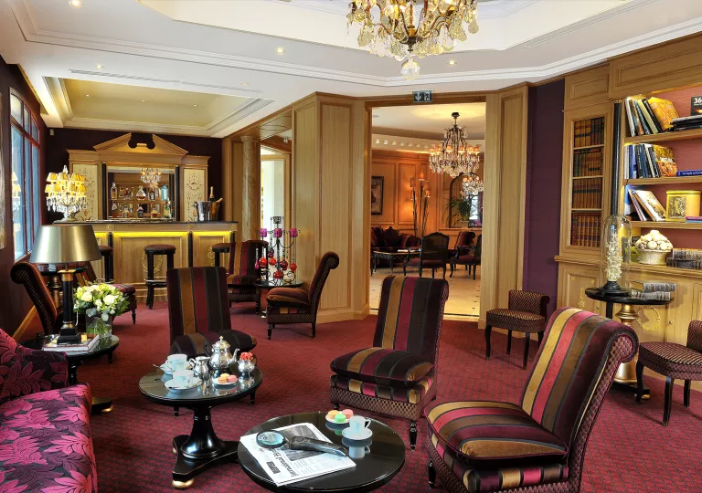 Indoor library, bar and lounge with red-striped cushioned chairs and circular tables