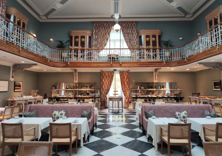 Large, two story foyer with tables on the ground floor and a balcony on the second floor