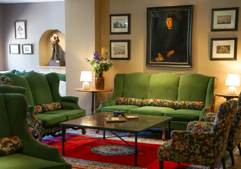 Indoor lobby with green sofas and painting on the walls