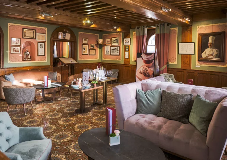 Indoor seating area with large, cushioned sofas and paintings on the wall