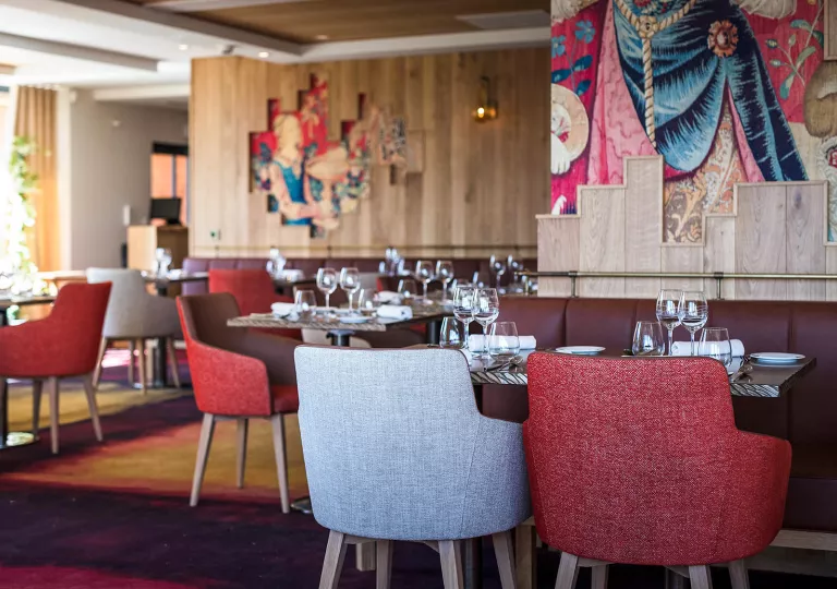 Indoor dining area with red and gray chairs with wine glasses on the tables