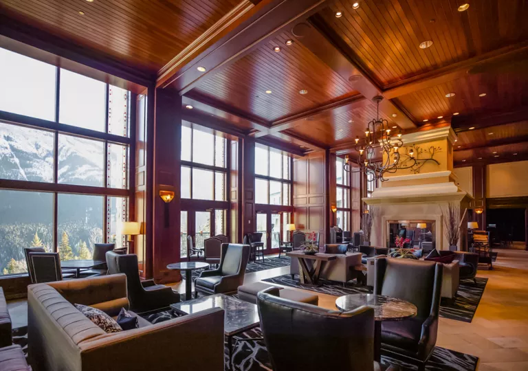 Indoor lounge and seating area with cushioned, leather chairs around coffee tables