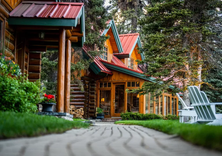 Wooden building with trees and lawn chairs on the right