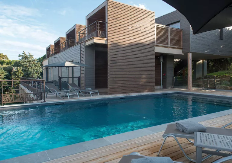 Outdoor pool with wooden walkways and metal, reclining chairs