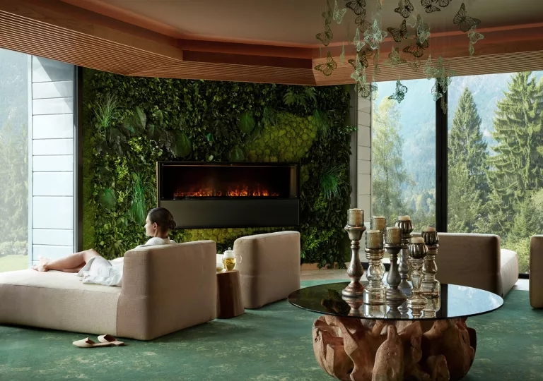 living room with fire place and view of forest