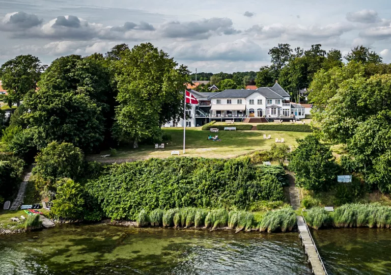 large house on a hill by the water