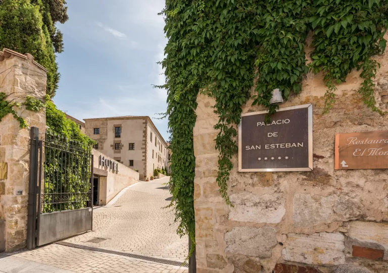 Hotel entrance with sign and green plants