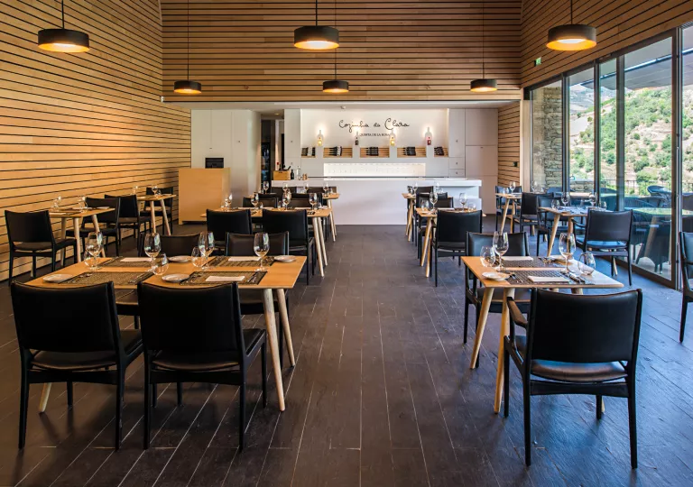 Indoor dining area with wooden tables and black cushioned chairs