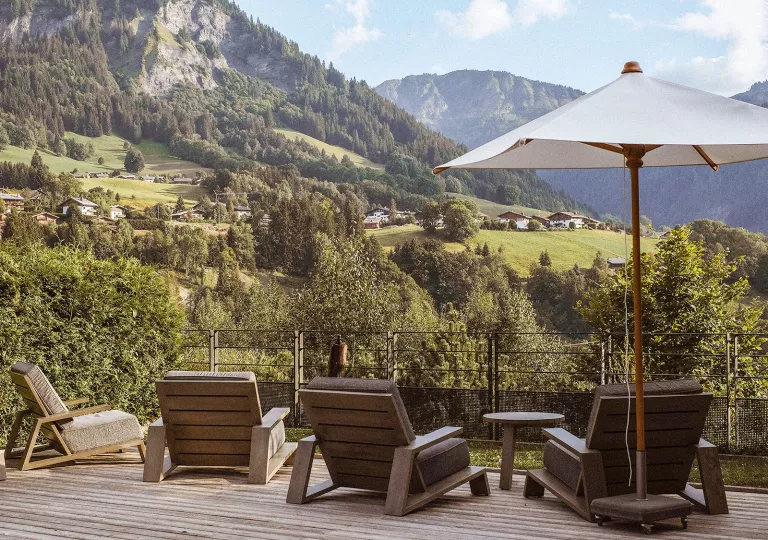 Outdoor balconies with an umbrella and brown cushioned chairs