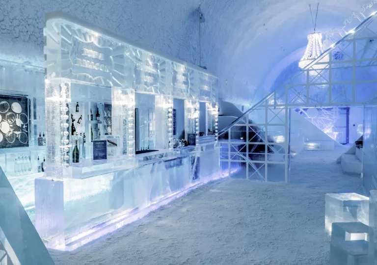 A liquor bar made of shaped ice, inside on an igloo-style room