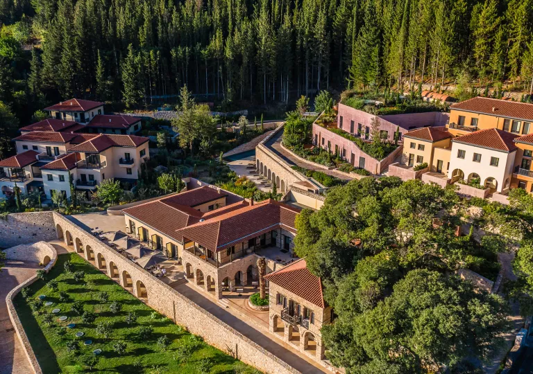 Three hotel properties surrounded by trees and a forest in the background