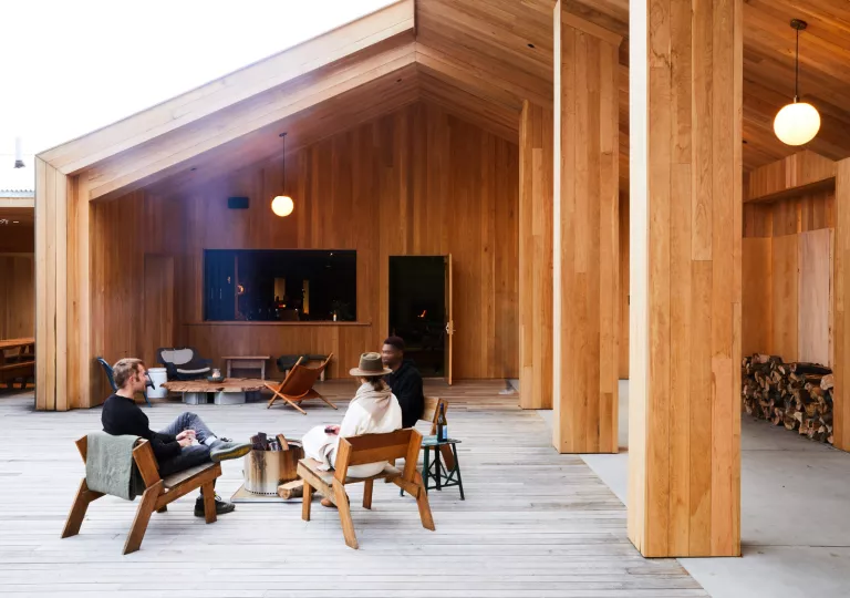 Three people sitting in an open wooden patio