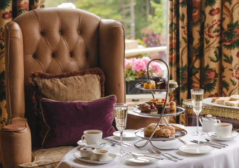 Leather couch with a white table full of pastries and tea