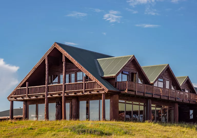 Outdoor view of wooden lodge with a green roof