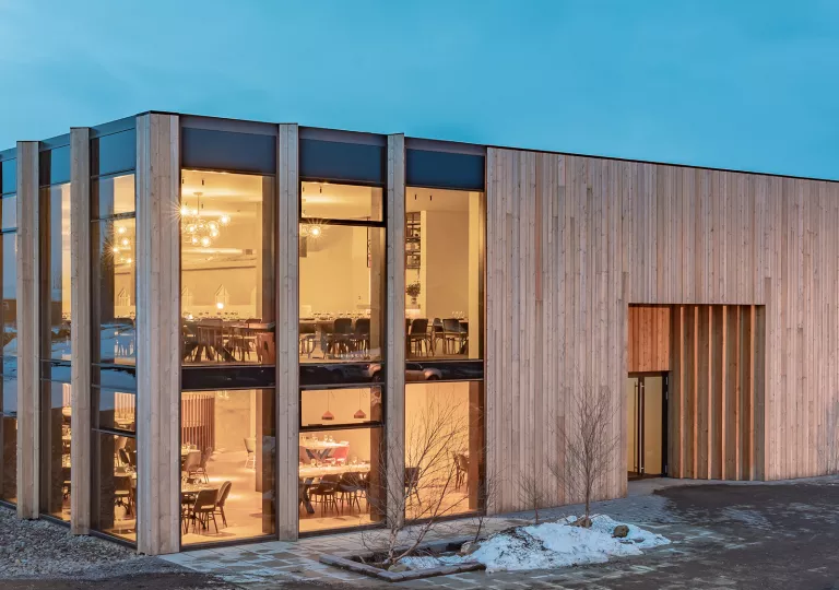 Wooden building with two stories of a dining hall with large, glass walls