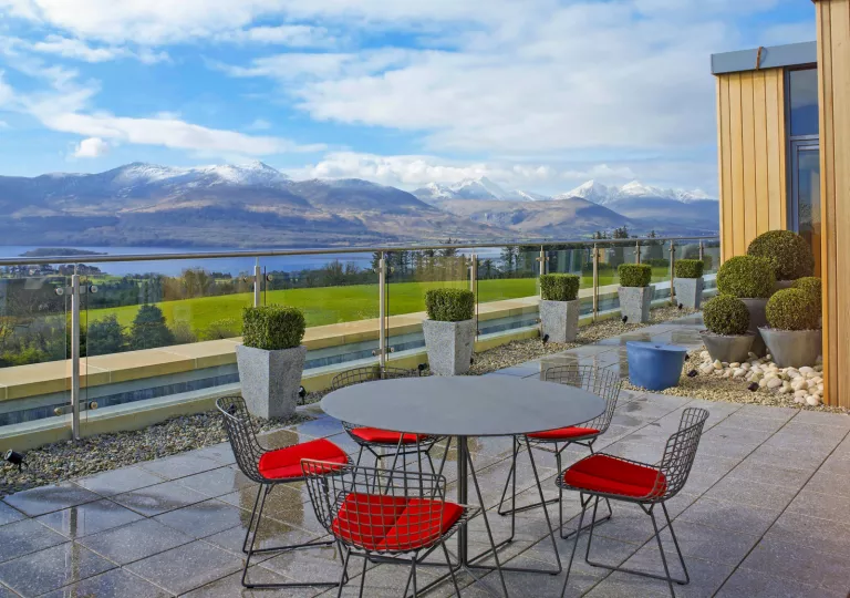 Outdoor patio with stone flooring and a circular table surrounded by chairs