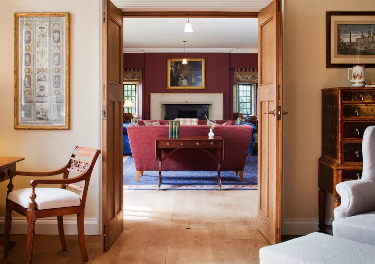 Living room area with open doors and cushioned chairs in the room