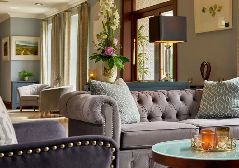 Seating area with cushioned, gray sofa with a circular glass table in front