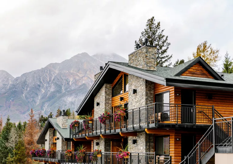 Wooden and stone cabin-styled building with flowers along the railings