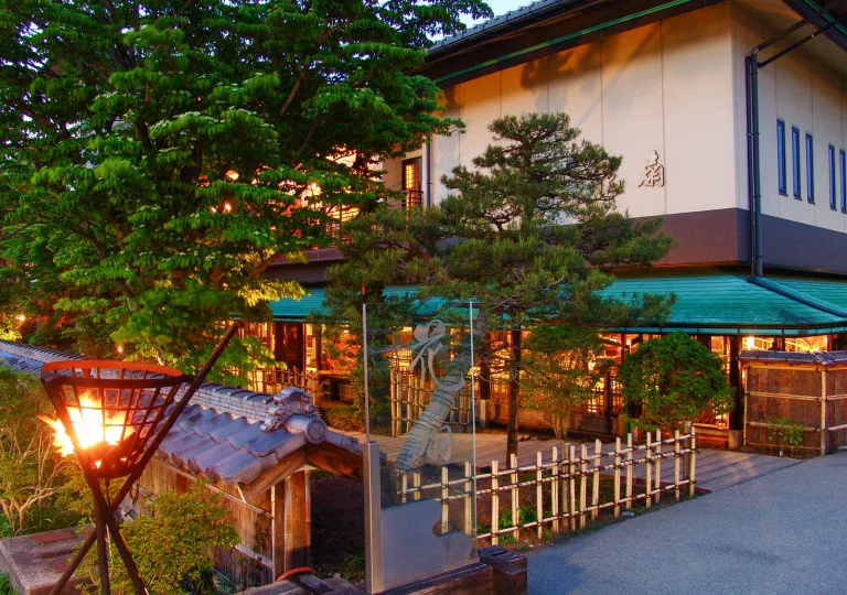 Building with traditional Japanese barricades, surrounded by trees