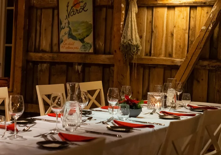 Indoor dining area with wooden walls and wine glasses on the tables