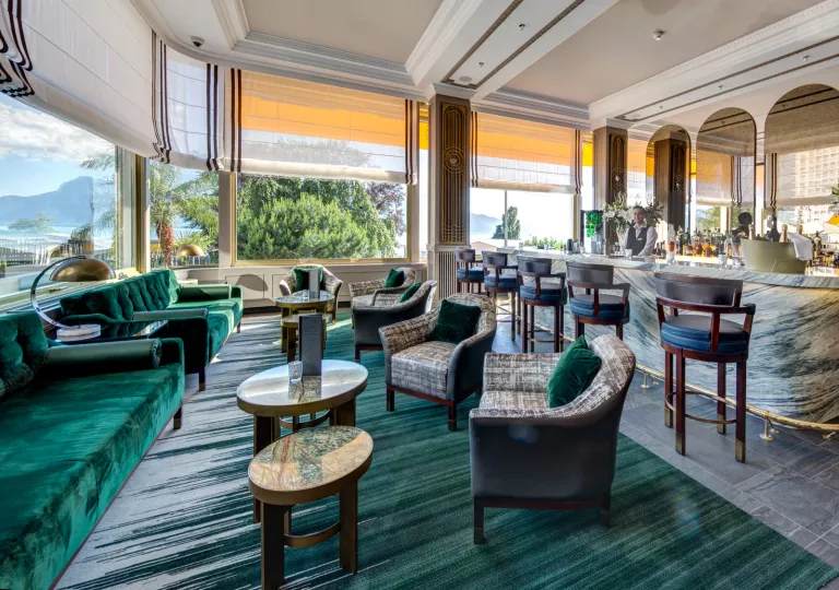 Bar and lounge with large open windows and a bartender in the background