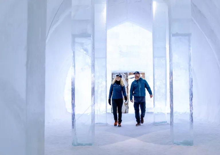 Man and woman inside of a room made of ice with molded ice pillars