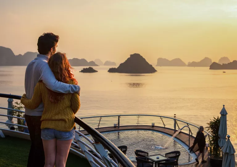 two people embracing and looking out at the sunset