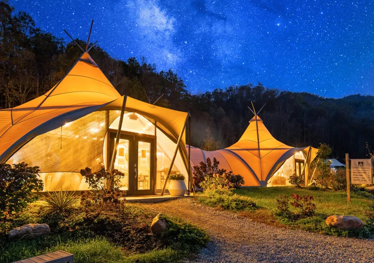 Illuminated white hut, with the midnight starry sky