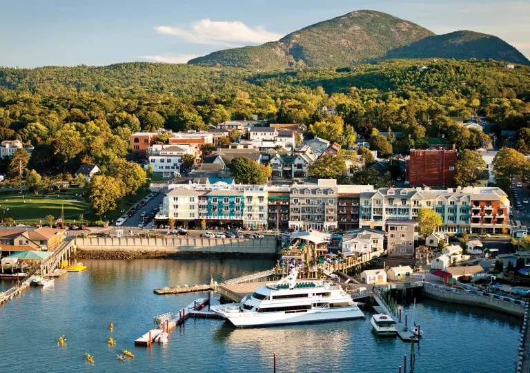 Coastline dock with a yacht and hotel buildings along the coast