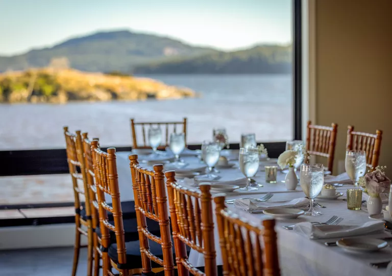 long dining room table with a view of the water