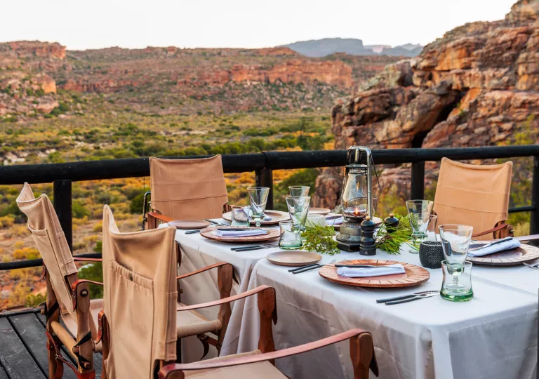 Outdoor dining table looking out towards orange and green canyons
