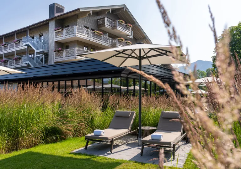 lounge chairs with umbrellas next to hotel