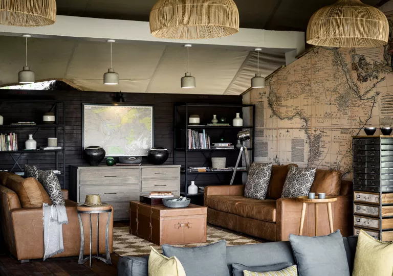 living room with leather couches, map wallpaper, and Raffa chandlier