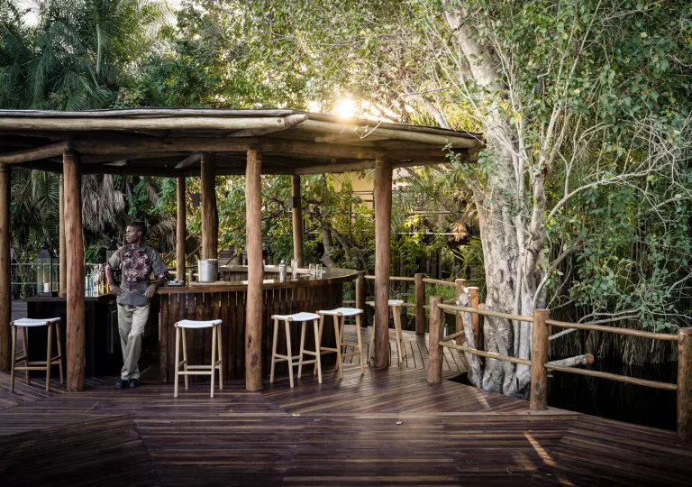 a man stands by a wooden outdoor bar