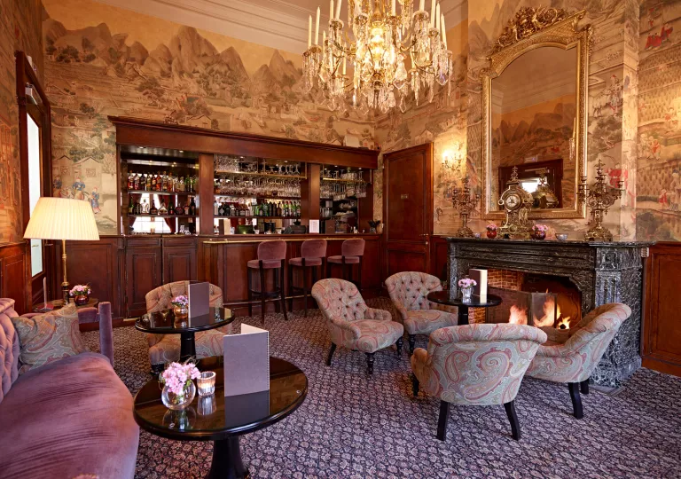 ornate living room with dark wallpaper and chandelier