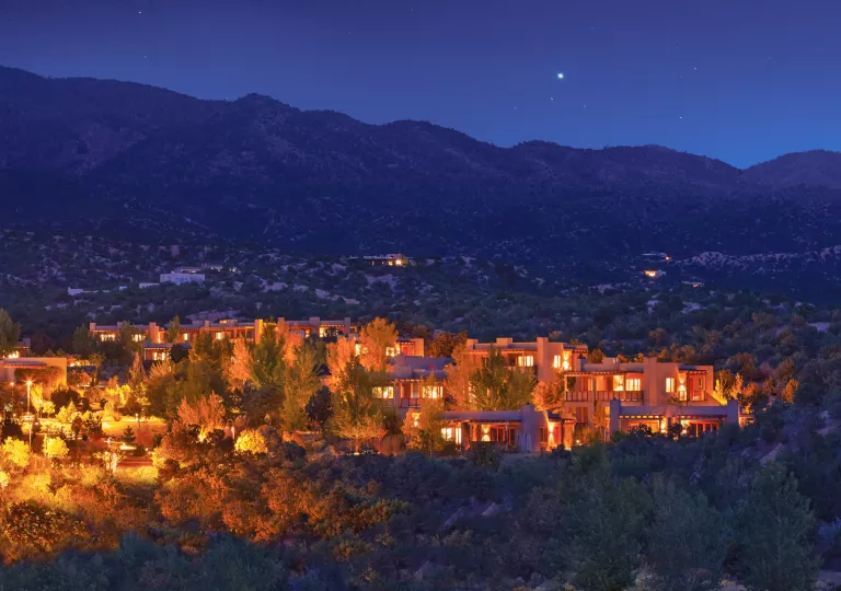 Hotel buildings illuminated by orange lights, surrounded by the forest