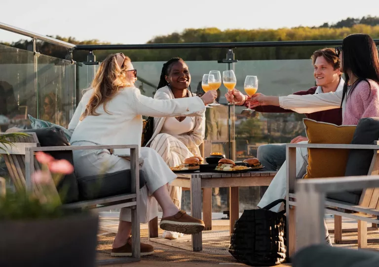 friends cheers wine glasses on a patio