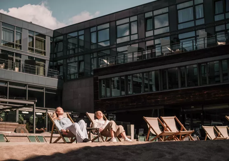guests lounge in the sun outside the hotel