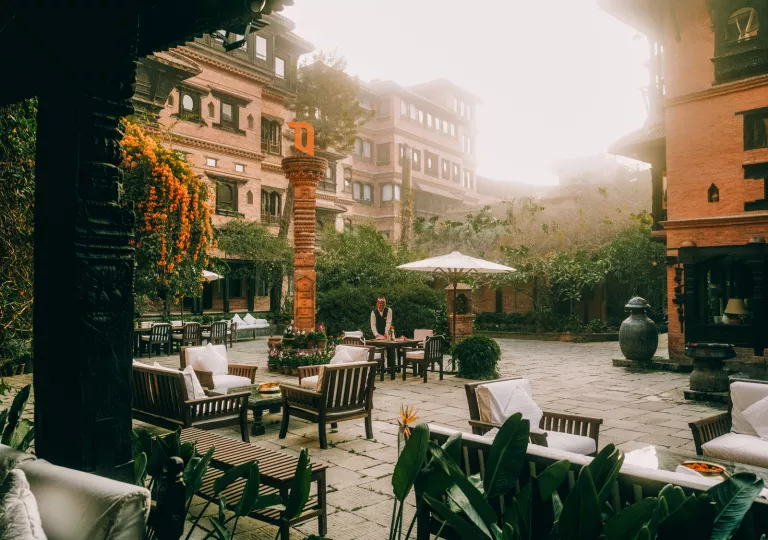 Outdoor courtyard with a waiter cleaning outdoor tables