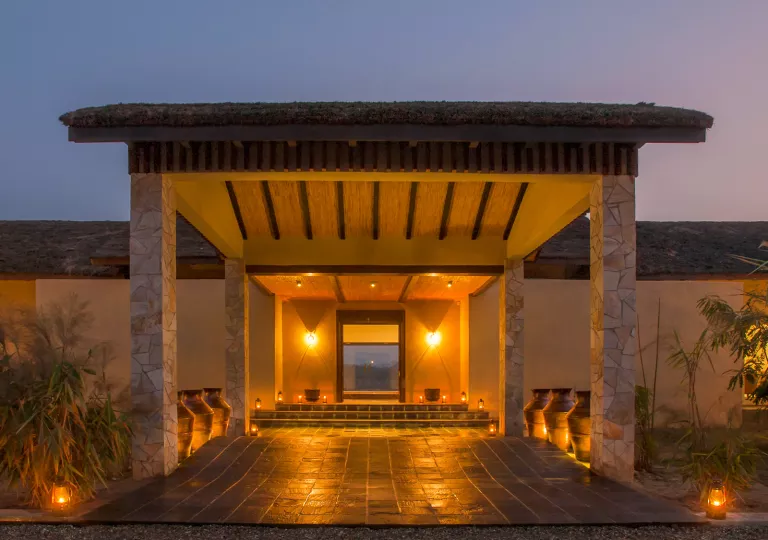 Stone building entrance, with a long path of stone and stone pillars