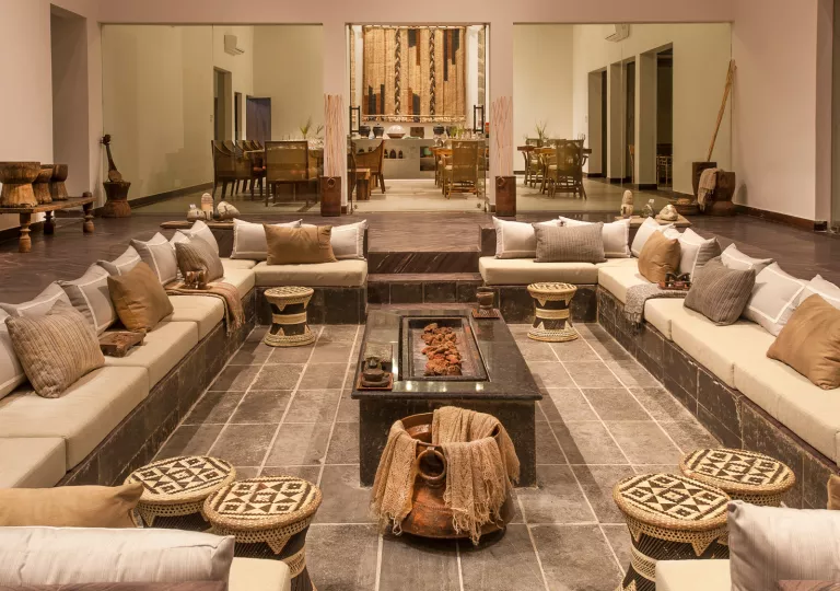 Indoor lounge with a large, square shaped seating area with cushioned sofas