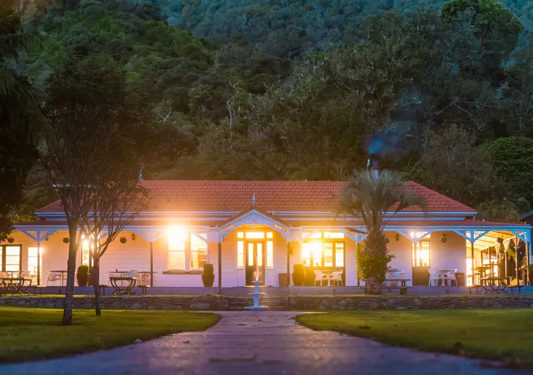 Lights coming out of a hotel building with a tall mountain behind it