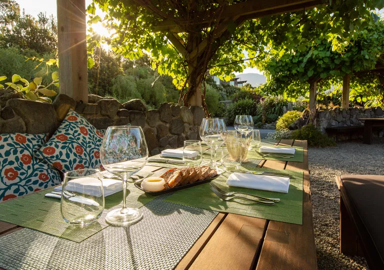 Outdoor table full of wine glasses and slices of bread