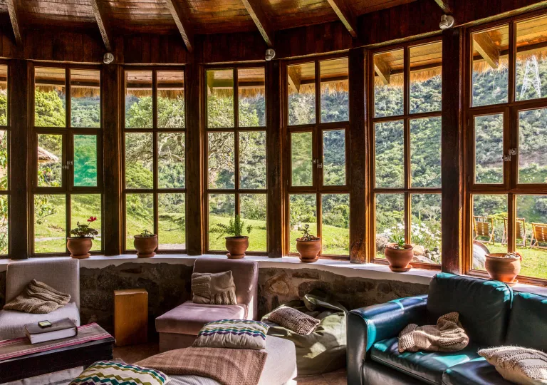 Cabin lounge area with cushioned seats and recliners, with large windows along the perimeter of the room