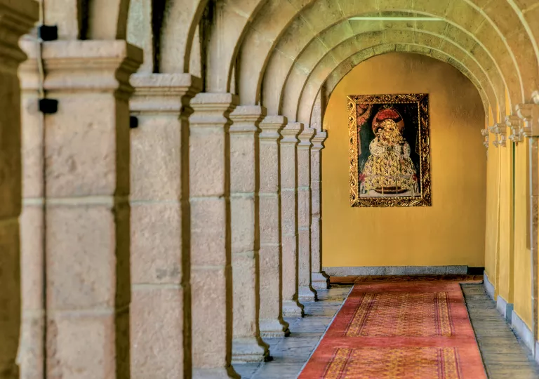 long hallway lined with columns and portrait at the end