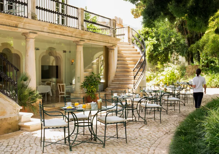 outdoor bistro tables next to a spiral staircase