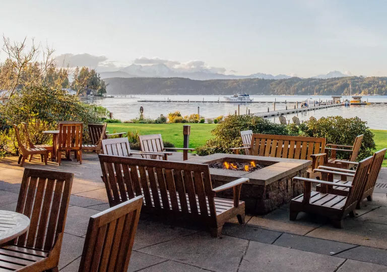 Wooden chairs around stone fire pits outdoors